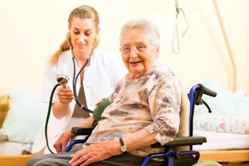 nurse checking the blood pressure of senior woman