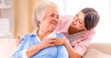 caregiver holding the hands of senior patient