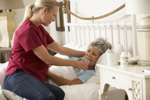 caregiver assisting senior woman on drinking water